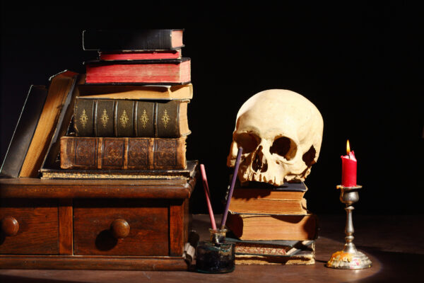 old books and skull over black