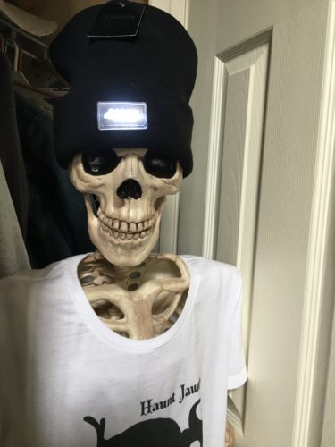 Skeleton in closet wearing LED hat