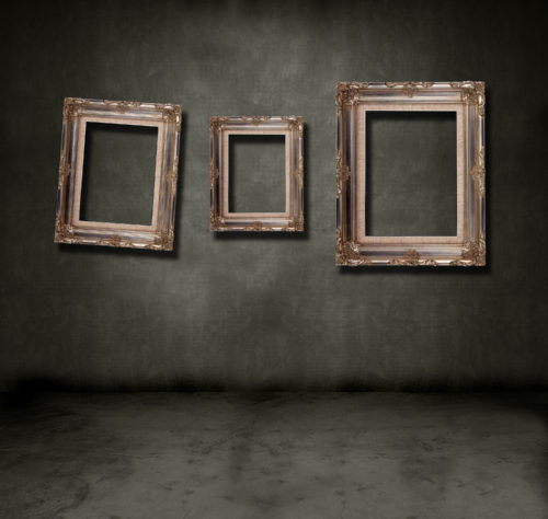 Three empty, crooked picture frames hanging on a creepy dingy wall.