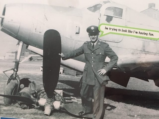 Ralph Mroch in uniform posing with a plane propeller