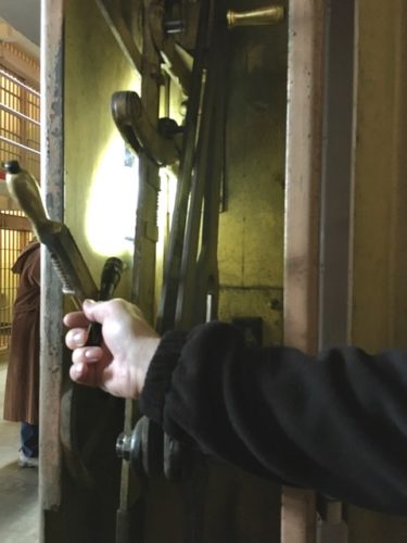 Volunteer at Alcatraz shining flashlight into box that opens cell doors.