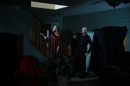 Amy Allan heads up a set of stairs on a walk through of a client's home in The Dead Files.