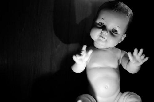 Cute but creepy baby doll in black and white.