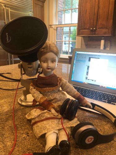 Eleanor the haunted doll with a mic getting ready to podcast