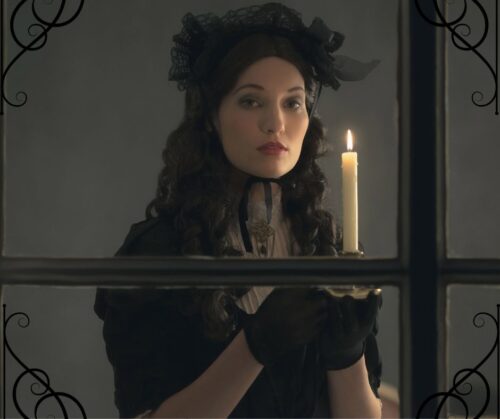 Lady in black Victorian clothing standing in a window with a candle