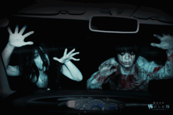 Two undead zombie ghosts on windshield at haunted drive-in