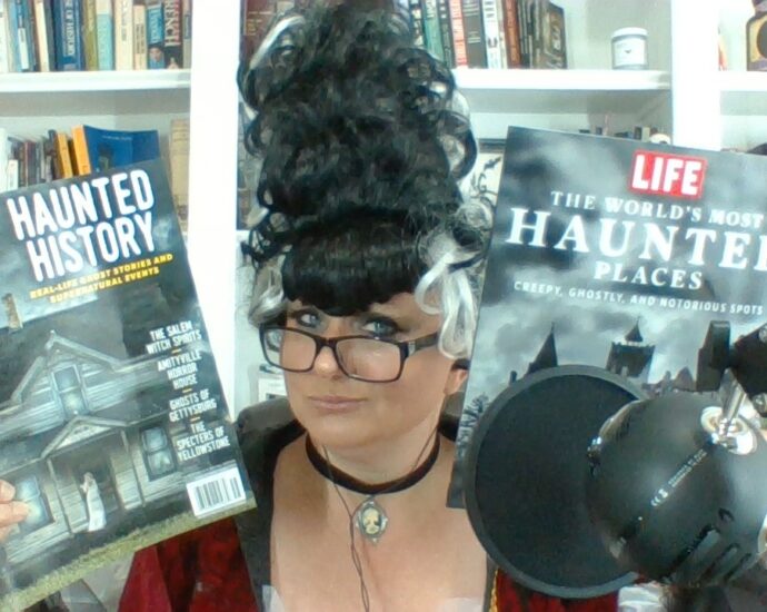 Courtney Mroch in Halloween costume holding up two magazines about ghosts, haunted places and the paranormal