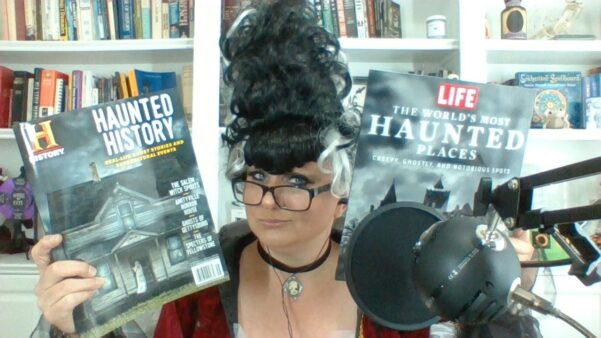 Courtney Mroch in Halloween costume holding up two magazines about ghosts, haunted places and the paranormal