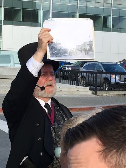 Anchorage ghost tour guide Rick Goodfellow holds up a historic photo during a tour.