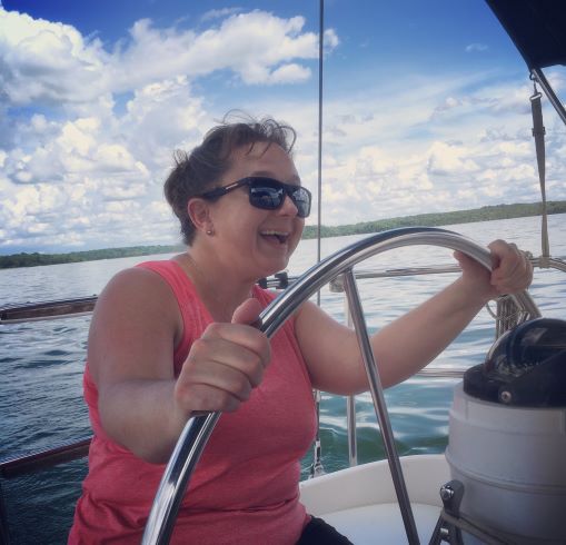 Courtney Mroch behind the wheel of a sailboat