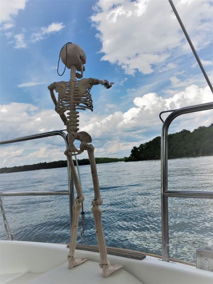 Smalls skeleton on the back of a boat pointing at Percy Priest Lake