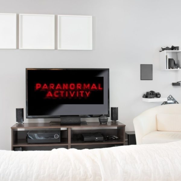 Paranormal Activity logo on TV in white bedroom