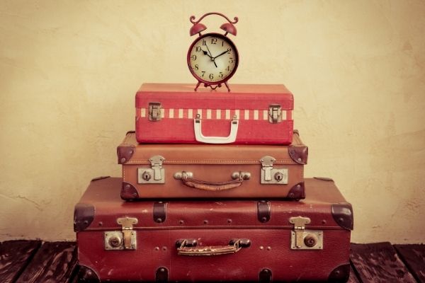 Time travel tours luggage with clock on top