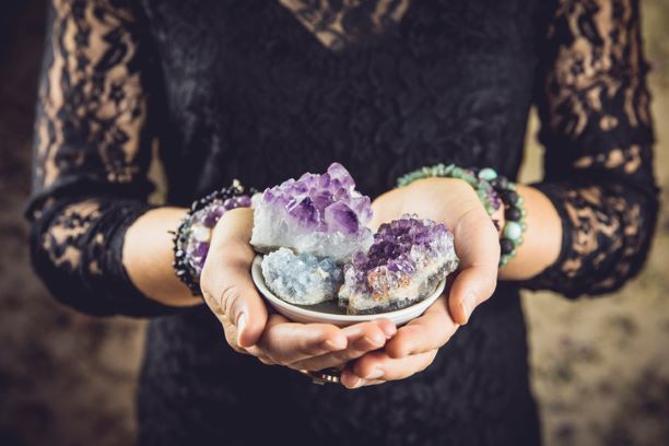 Witch woman in black holding crystals