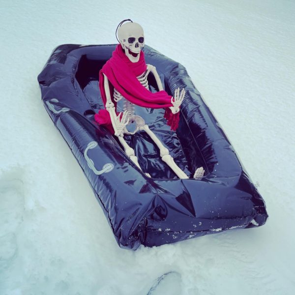 Skeleton sledding on snow in coffin float