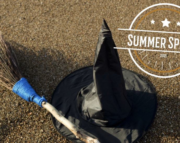 Summer Spirit witch hat and broom on sandy beach