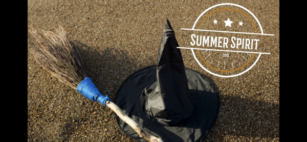 Summer Spirit witch hat and broom on sandy beach