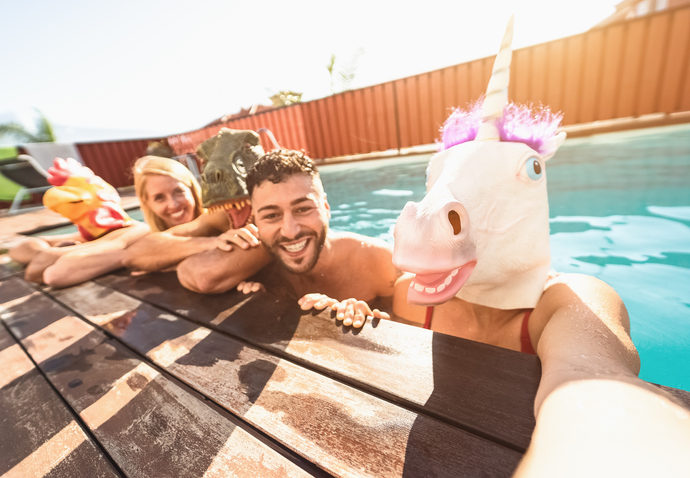 Crazy friends selfie doing pool party wearing bizarre mask - Young people having fun celebrating summer in exclusive tropical resort - Friendship and youth holidays lifestyle concept