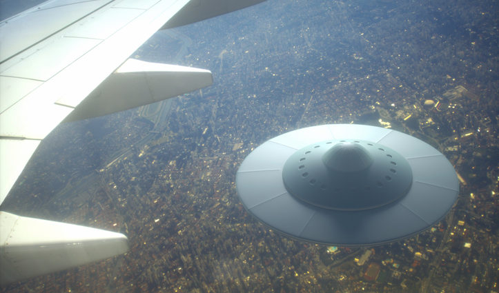 UFO under wing of an airplane in the sky