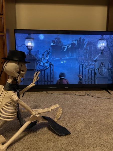 Skeleton watching Gonza and Pepe walking through Haunted Mansion gates