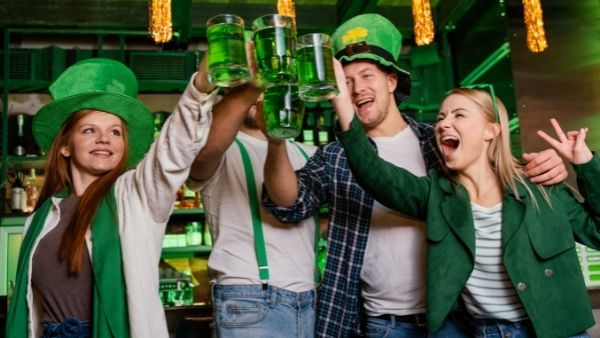 Friends in a bar with green beer toasting St. Patrick's Day