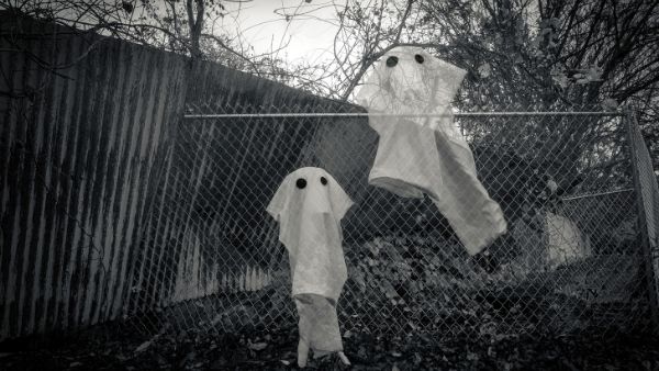 2 ghosts climbing or escaping over a fence