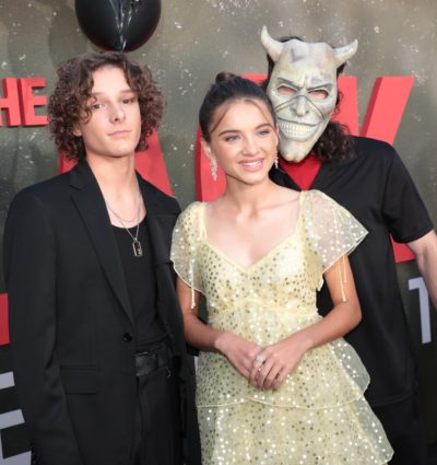 Mason Thames and Madeleine McGraw pose with the Grabber during the premiere of The Black Phone.