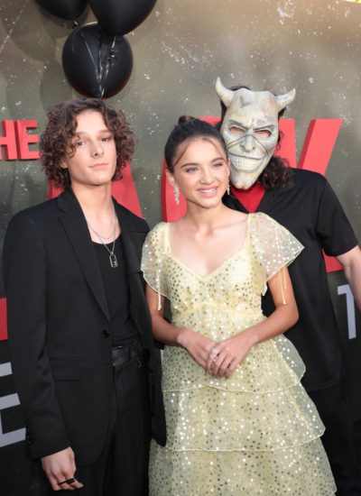 Mason Thames and Madeleine McGraw pose with the Grabber during the premiere of The Black Phone.