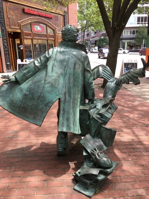Backside of Edgar Allan Poe statue with heart on books