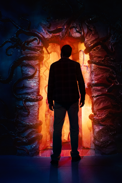A man stands in front of the entrance to the Upside Down at Stranger Things: The Experience.