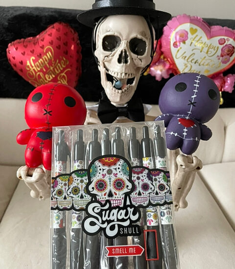 Smalls skeleton in top hat and bowtie with red and purp0le voodoo dolls and sugar skull pens for Valloween 2023