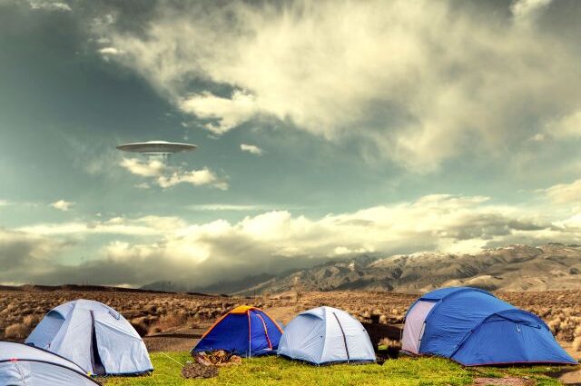 Campground with tents in a valley and UFO in the sky