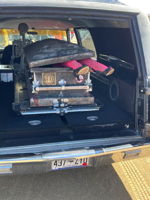 A Frozen DXead Guy Days hearse with stockinged legs and heels coming out of the coffin