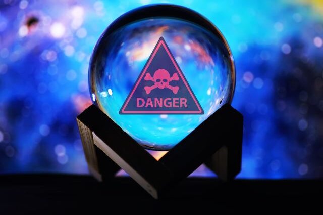 Psychic crystal ball with danger skull and crossbones warnings sign in it