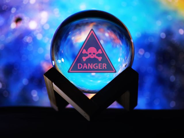 Psychic crystal ball with danger skull and crossbones warnings sign in it