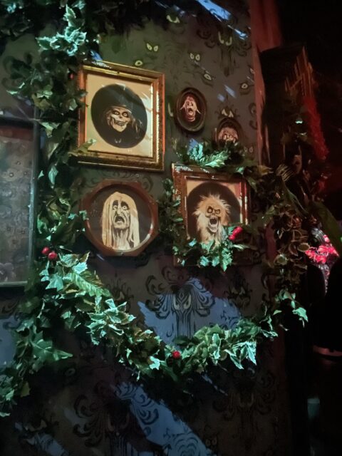 Haunted Mansion creepy Hatbox Ghost portrait and otehr framed photos decorated for Nightmare Before Christmas